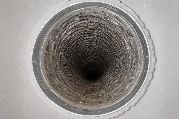 Inside a Dallas home's supply air duct before cleaning, coated with years of dust and debris