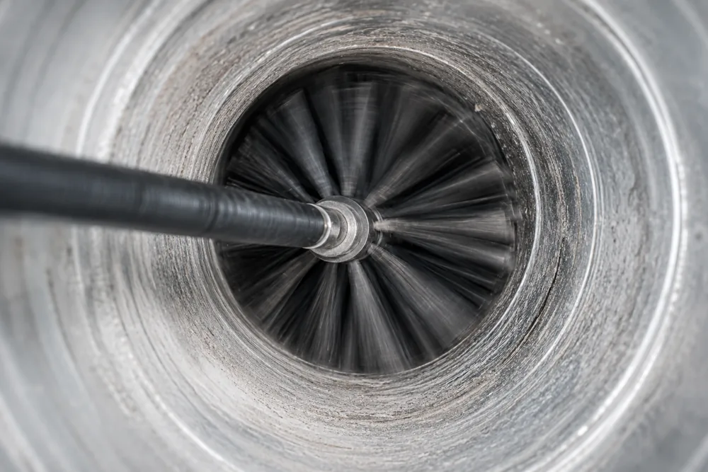 Rotating brush cleaning the inside of a round air duct