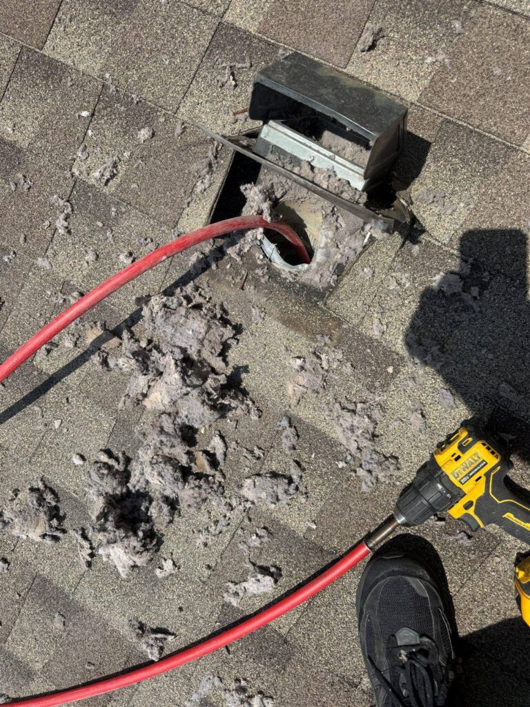 Opened rooftop dryer vent with lint removed during repair in Dallas, TX